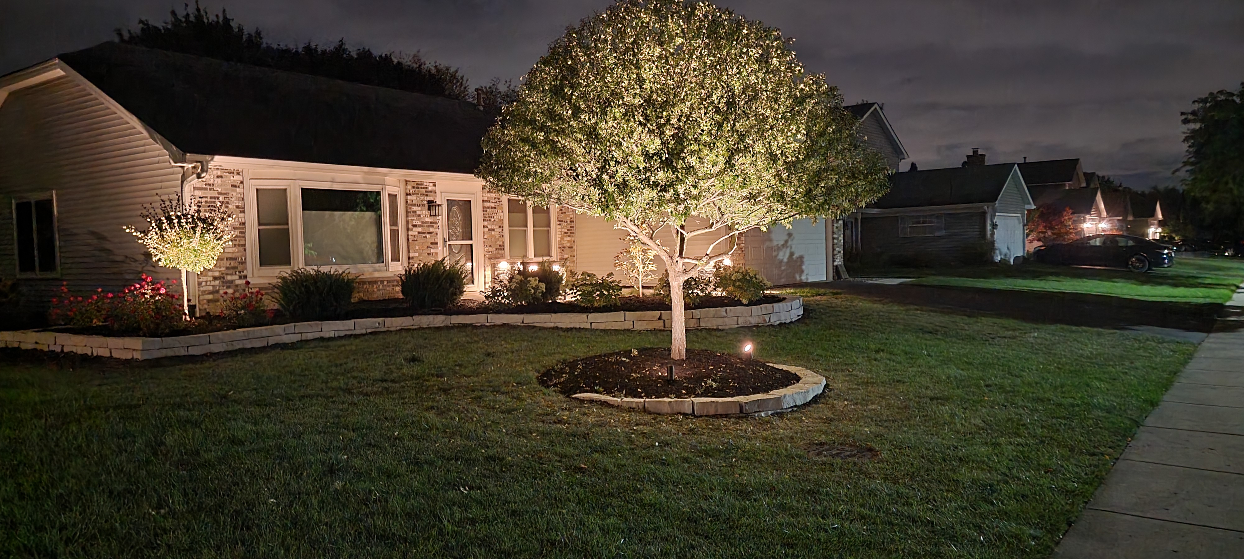 Front natural stone retaining wall at night with landscape lights, Carol Stream, IL — B&L Landscape