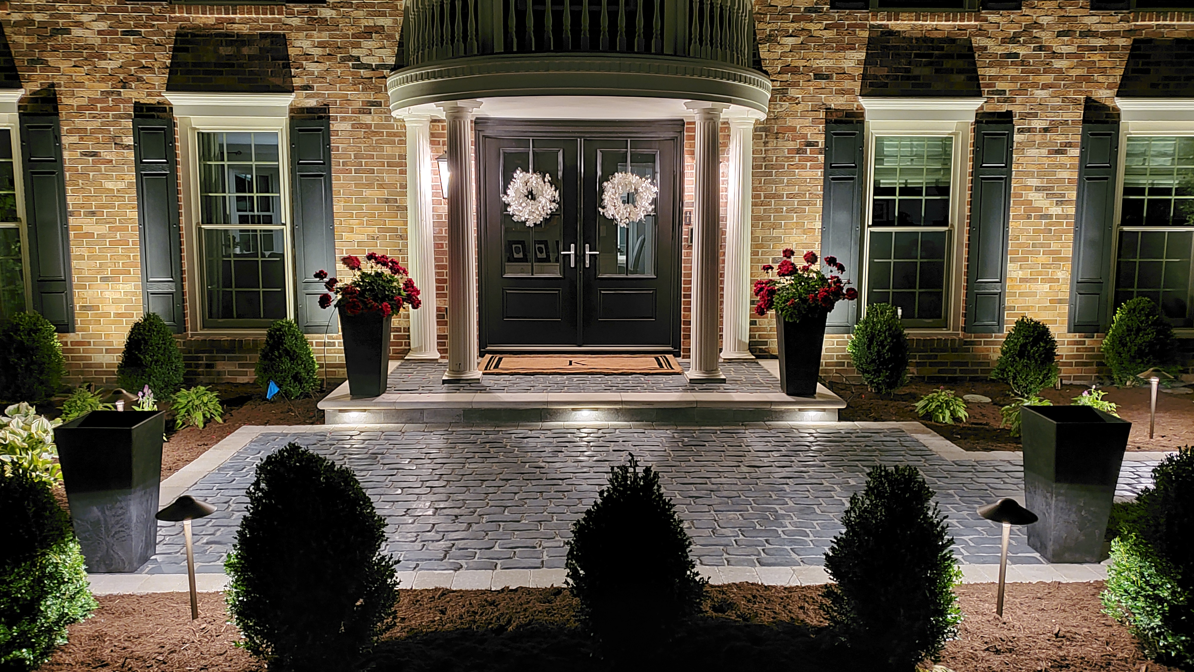 Front door with paver walkway at night with landscape lights, St. Charles, IL — B&L Landscape